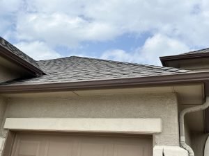 closeup photo of taupe guttering over garage area on tan stucco home